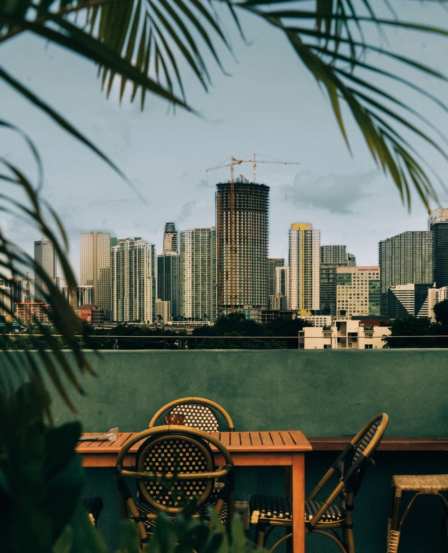 Rooftop tables and woven chairs at Terras with the Miami skyline beyond.